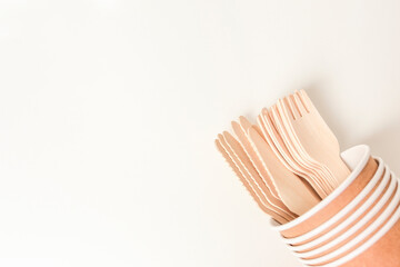 Eco travel utensils, zero waste concept. Sustainable lifestyle. Paper cup and wooden cutlery with copy space, top view.