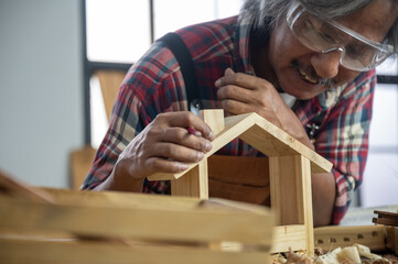 old carpenter man working from home with wood handmade, craft product wooden work production at home