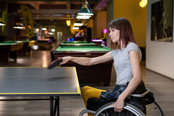 Young disabled woman in a wheelchair playing table tennis
