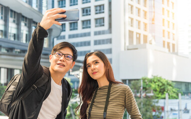 Fototapeta premium Happy young traveller couple of tourists taking selfie in the city.