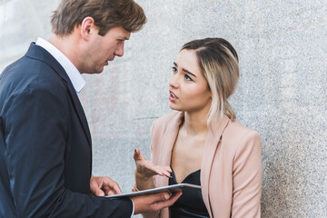 Young business couple disputing about business in the city.
