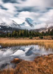Mount Assiniboine with cloudy blowing on golden meadow at provincial park
