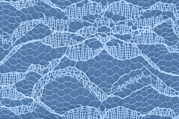 Delicate lace textured material on blue knit background