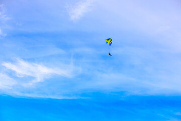 A flying paramotor on a vibrant sky with cloud.