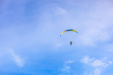 A flying paramotor on a vibrant sky with cloud.