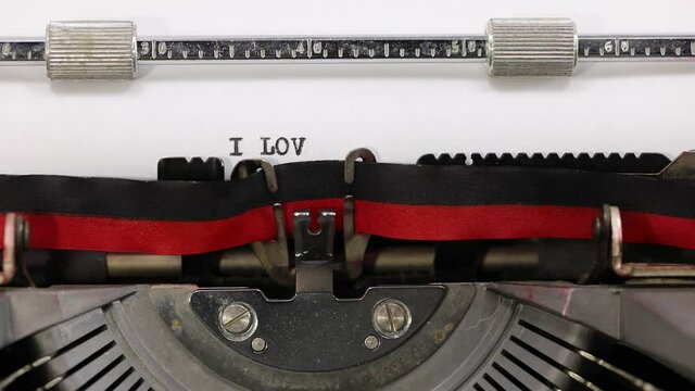 writing on the vintage typewriter the text I Love You on the white sheet