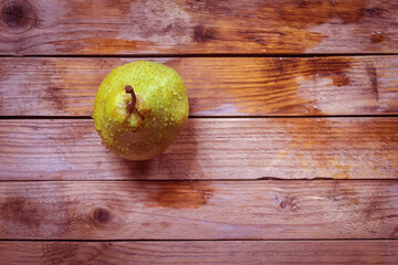 View from above on a juicy and ripe pear with drops of water