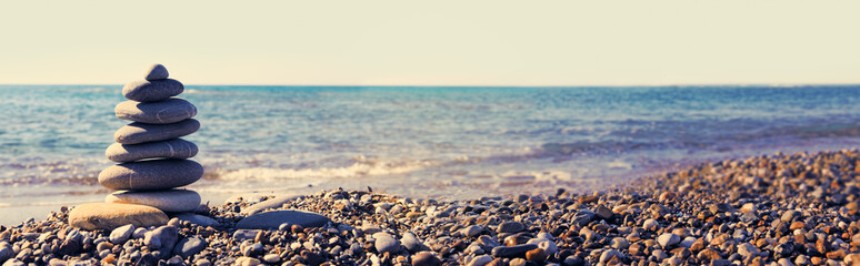 Relax nature concept on sea. Spa gray stones balance on beach.