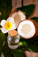 Obraz na płótnie Canvas natural coconut walnut oil with coconut and flower nearby.