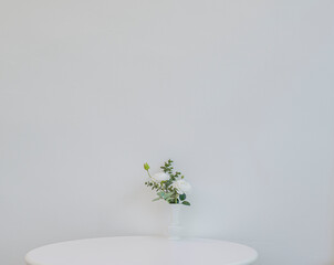 원형 테이블 위에 화병과 흰색 장미꽃
