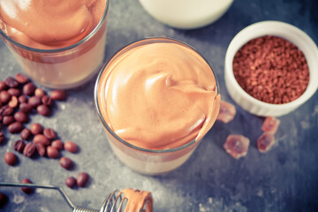Dalgona Coffee. Fluffy creamy whipped coffee on the concrete background. Trendy beverage.