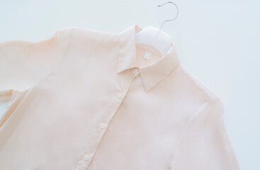 옷걸이에 걸려 있는 핑크 베이지 셔츠