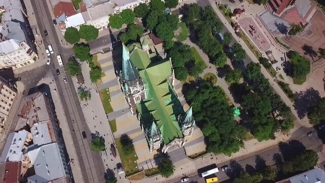 Old catholic church, street traffic life and buildings. Drone aerial video of Saint Olga and Elizaveta Church in central part of old city of Lviv, Ukraine. 