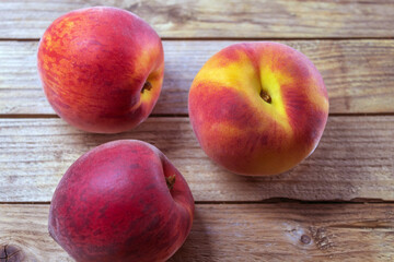 Fototapeta na wymiar Three fresh juicy peaches close up on a wooden background