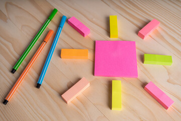Colorful sticky notes and pens on wooden table