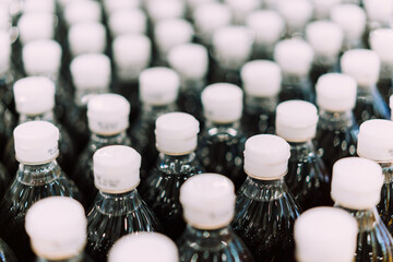 Close up row of plastic bottles neck pattern contain soy sauce are moving in conveyor production...
