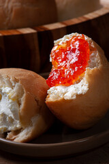 
Homemade bread in a wooden bowl accompanied by curd and jam