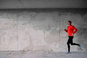 Obraz na płótnie Canvas Side view of runner running fast under the bridge.