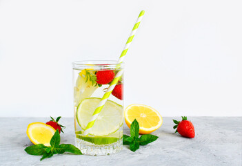 Refreshing summer lemonade in a glass cup from lemon, lime, strawberry, orange, mint on a white background. Flax drinks. Detox, healthy eating, fitness drinks. Copy space.