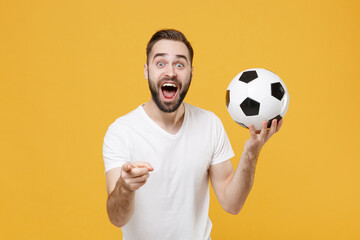 Shocked bearded man guy football fan in white t-shirt isolated on yellow background. People sport...