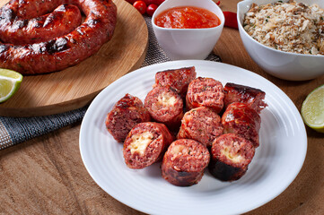 .Grilled Brazilian sausage stuffed with cheese on a wooden board. Brazilian barbecue.. Selective focus