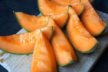 Melon coupé sur une planche en été.