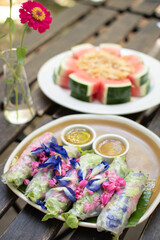Meang Dokmai, is the name of fresh vetgetables and some flower wrapped in noodle sheet, dip in spicy sauce