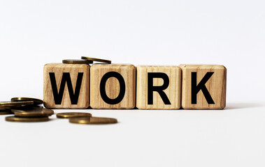 wooden cubes and WORK, coins, the concept of taxation, increase taxes and fees
