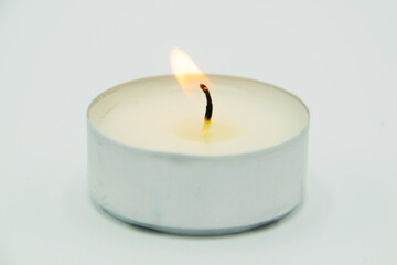 burning wax candle on gray background