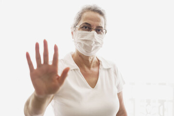  Elderly woman wearing a mask expressing her hand not approaching her.