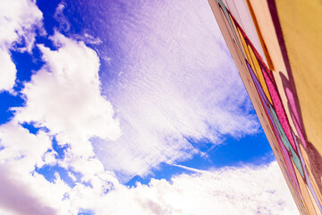 Intense blue sky with white clouds crossing an urban building.