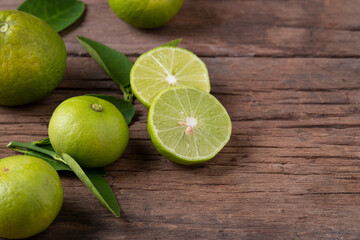Half sliced lime fruits on wood plate