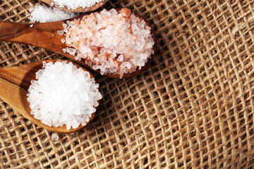 Sea salt and himalayan on spoon. Crystals of salt on background
