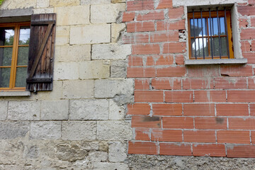 Fototapeta na wymiar Raccord pierre et brique sur un mur de maison