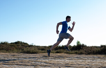 man sprinting in the countryside