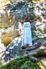 Girl in a white dress on a background sand cliff Sietiniezis on the Gauja river banks in Vaidava, Latvia