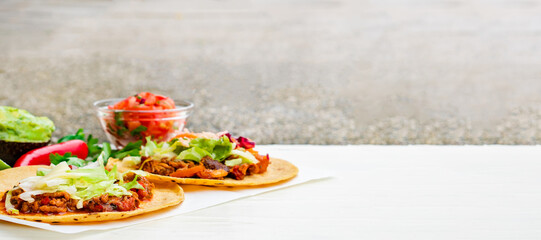 Mexican traditional authentic homemade tacos with pulled pork beef chili con carne serve with tomato salad and avocado guacamole and dip sauce