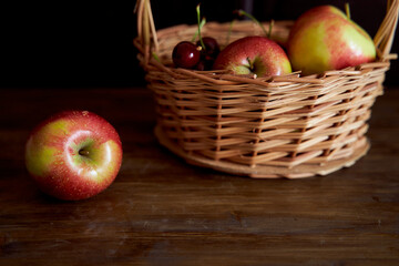 Braided basket with red apples on a black background