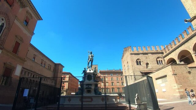 Bologna timelapse in 4k: view of Neptune statue ( statua del nettuno ) in the main square ( piazza maggiore) during a sunny day. Blue clear sky with some clouds in background. 