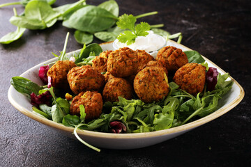 roasted falafel chickpeas patties with garlic yogurt sauce on table