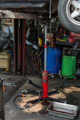 Axle or jack holding car in garage. 
