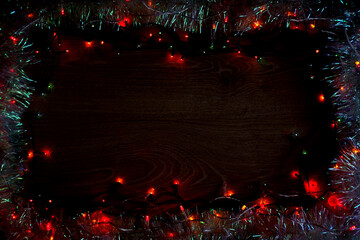 Red garland frame on dark wood. Festive decorative background for christmas celebration