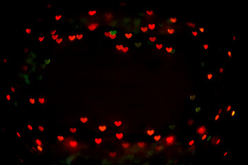 Fototapeta na wymiar Valentine's day red bokeh hearts on black background