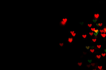 Little red bokeh hearts on black background. For Valentine's Day celebrations