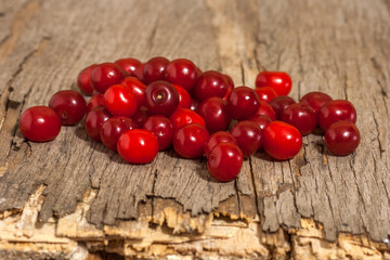 Pile of scattered cherry berries on an old wooden table