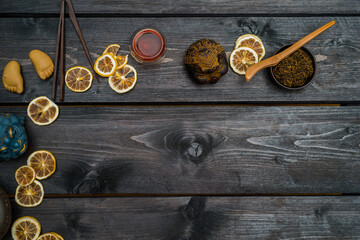 Chinese tea with dry bergamot and different tools and figurines. Frame on black wooden table. View from above