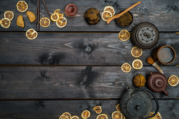 Chinese tea with dry bergamot and different tools and figurines. Frame on black wooden table. View from above