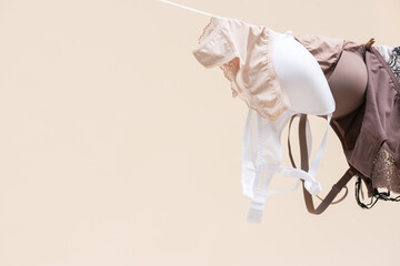 Female underwear is hanging on the rope on light background.