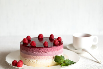 Composition on a light background, a dish with mousse cake and a Cup of red tea karkade. The concept of proper dietary nutrition and cake day. Selective focus.