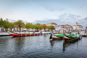Fototapeta na wymiar Colorful Moliceiro boat rides in Aveiro are popular with tourists to enjoy views of the charming canals.
